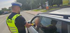policjant podczas kontroli drogowej kierującego samochodem osobowym