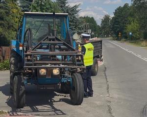 policjant podczas kontroli drogowej kierującego ciągnikiem rolniczym