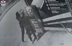 zdjęcie z nagrania z kamery dwaj mężczyźni przy urządzeniu do wpłacania pieniędzy na myjni samochodowej