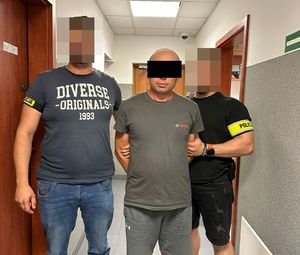 dwóch nieumundurowanych policjantów i zatrzymany mężczyzna