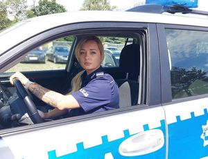 policjantka siedzi w samochodzie zaparkowanym na parkingu
