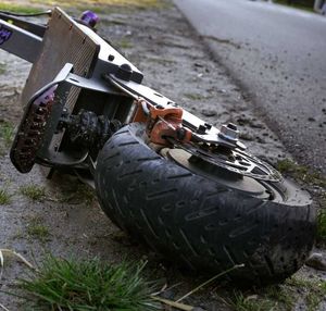 leżąca na drodze hulajnoga, w tle samochody