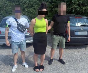 policjanci prowadzą zatrzymaną kobietę