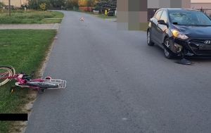 Miejsce zdarzenia drogowego z lewej strony stoi uszkodzony damo chód osobowy Hyundai a po prawej stronie na poboczu leży rower koloru różowego