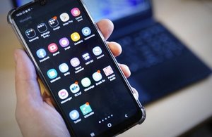 Zdjęcie zajawkowe. Trzymany w ręku smartfon z aplikacjami