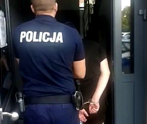 policjant prowadzi zatrzymanego mężczyznę