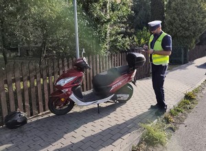 Policjant wykonuje oględziny motocykla