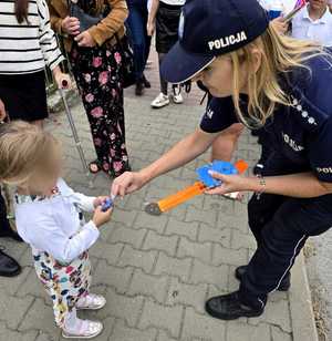 policjantka rozdaje dzieciom odblaski