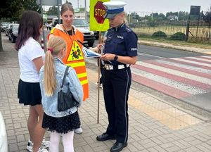 policjantka pod szkołą z uczniami