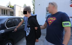 policjanci prowadzą zatrzymanego mężczyznę