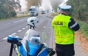 policjant drogówki mierzy prędkość pojazdów