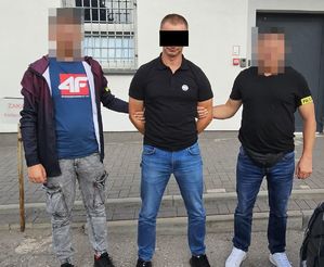 policjanci prowadzą zatrzymanego mężczyznę