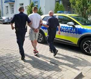 doprowadzenie do radiowozu przez dwóch policjantów 39 letniego sprawcy kradzieży i kierowania w stanie nietrzeźwości