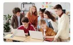 młodzież przed siedząca przed laptopem