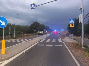 Miejsce wypadku, na pierwszym planie widać przejście dla pieszych, w oddali po lewej stronie stoi samochód koloru białego, strażaków i czerwony parawan.