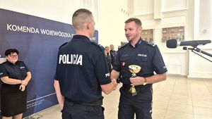 Komendant Robert Michna wręcza puchar policjantowi