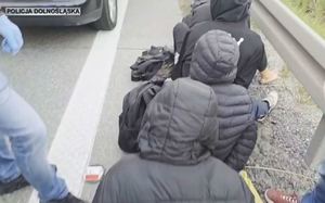 osoby siedzące przy drodze