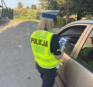 policjantka przy samochodzie rozmawia z kierowcą