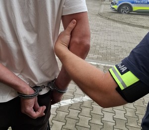 policjant prowadzi zatrzymanego
