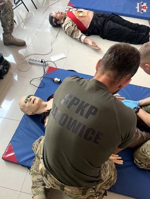 policjant z w koszulce z logo SPKP Katowice podczas zajęć praktycznych udziela pomocy