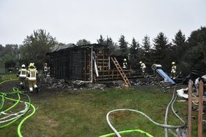 strażacy na miejscu pożaru domu