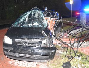 uszkodzony pojazd osobowy po uderzeniu w ogrodzenie