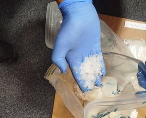 dłoń w rękawiczce, a na niej kryształki mefedronu