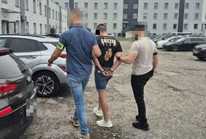 policjanci prowadzą zatrzymanego