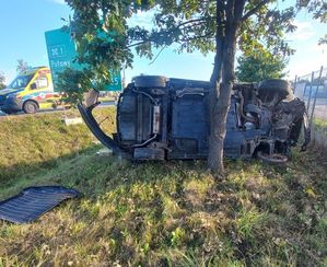 samochód leżący na boku w tle karetka