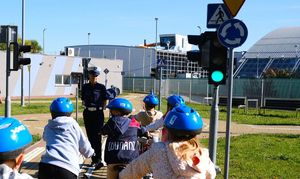 policjantka z dziećmi na miasteczku ruchu drogowego