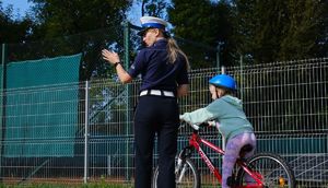 policjantka z dziećmi na miasteczku ruchu drogowego