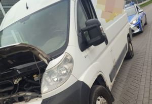 Biały bus kontrolowany przez policję. Z tyłu radiowóz