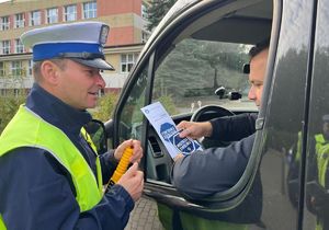 &quot;policjant przekazujący ulotki kierowcy