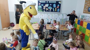 Maskotka mrówka rozdaje dzieciom odblaski