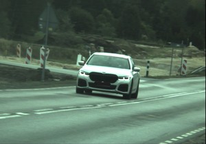 BMW koloru białego jedzie po drodze krajowej numer 48.