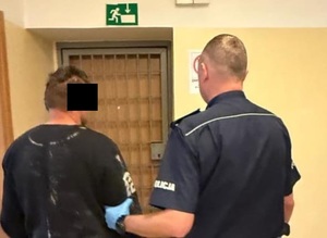 policjant z zatrzymanym mężczyzną