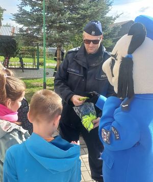policjant rozdaje dzieciom odblaski
