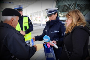 policjanci rozdają odblaski na dworcu