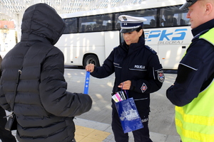 policjanci rozdają odblaski na dworcu
