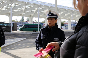 policjantka rozdaje odblaski na dworcu