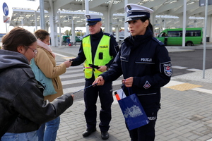 policjanci rozdają odblaski na dworcu