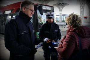 policjanci rozdają odblaski na dworcu
