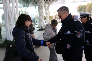 policjanci rozdają odblaski na dworcu