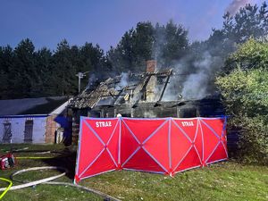 parawan koloru czerwonego zasłaniający zgliszcza spalonego domu