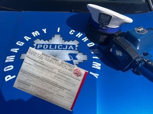 czapka policyjna i urządzenie do pomiaru prędkości na masce radiowozu