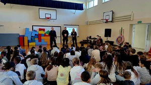 policjanci w trakcie prelekcji na sali gimnastycznej stający przed uczniami