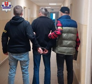 zatrzymany doprowadzany do sądu w asyście dwóch  policjantów w ubraniach cywilnych