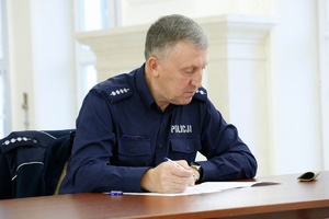 policjant siedzi przy stole i rozwiązuje test