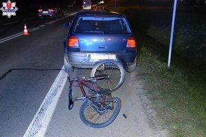 na jezdni stoi osobowy Volkswagen przed nim leży rower