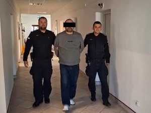 mężczyzna na korytarzu, obok policjanci